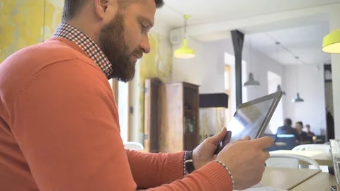Man browsing tablet computer, close profile shot, in cafe Vídeos de archivo 73292361