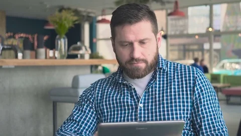 Man browsing tablet computer, looking at camera in cafe, portrait steadicam shot Stock Footage 72947498