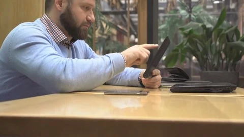 Man browsing tablet computer in pub, cafe, profile, steadicam shot 库存影片 73075822