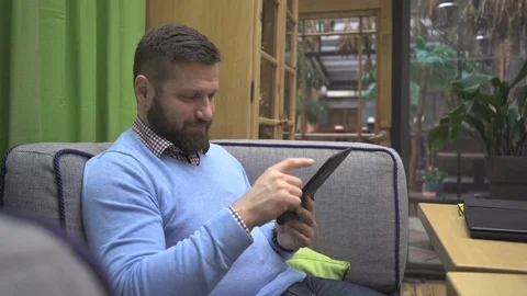 Man browsing tablet computer, in pub, cafe, indoor, steadycam shot 库存影片 73077207