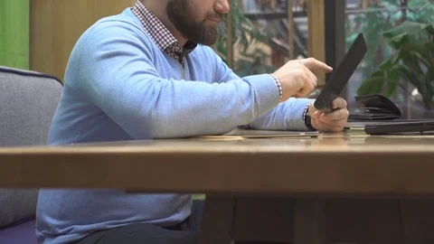 Man browsing tablet, lomoking at camera smiling, in pub, steadicam Vídeo Stock 73075903