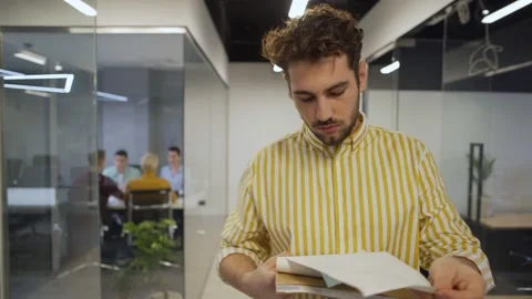 Man browsing through notepad in office corridor Stock Footage 132941545