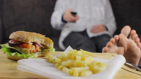 Man Browsing TV Channels and Eating Fast Food non excl Stock Footage 95259785