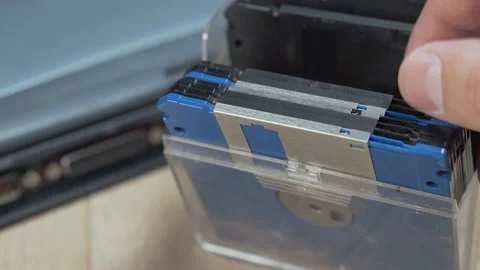Man browsing vintage computer floppy disks in a storage box. Stockbeeldmateriaal 149424165