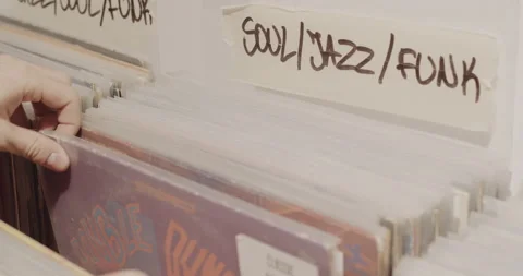 Man browsing vinyl collection of jazz, soul and funk records in a music store Stock Footage 146727898