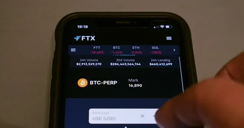 Man browsing website of FTX (FTX Cryptocurrency Exchange) on iPhone Stock Footage 221124088