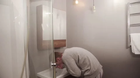 The man brushed his teeth, rinsed his mouth, washed his face and dried it with a Stock Footage 145072018