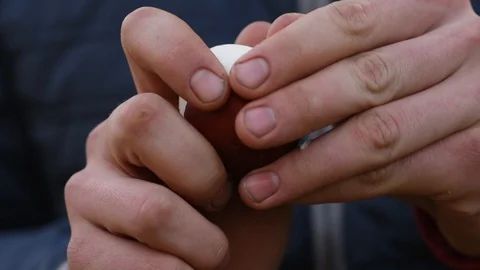 Man brushes boiled egg with his hands Stock Footage 128816676