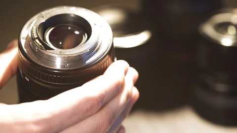 The man brushes dust from the lens of the camera lens and checks the cleanliness Stock Footage 126536427