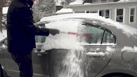 Man Brushes Snow off side of a Grey Car Stock Footage 147672876
