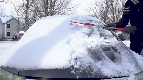 Man Brushes Snow off the Windshield of a Grey Car Stock Footage 147682456
