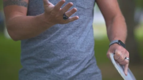 Man Brushing off a Frisbee Disc Stock Footage 91666004