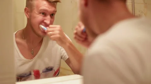 A man brushing his teeth in the bathroom at home Stock Footage 64944911