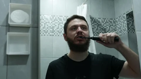 Man brushing his teeth in front of mirror, close-up shot   Stock Footage 331241728