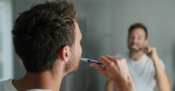 Man brushing his teeth getting ready in the morning doing hygiene routine Video stock 86031520