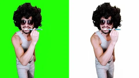 Man brushing his teeth on a green background 스톡 동영상 296789395