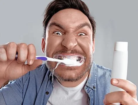 Man brushing his teeth with a toothpaste Stock Photos