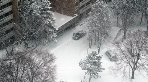 Man brushing snow off car during a heavy snowfall Stock Footage 48551561