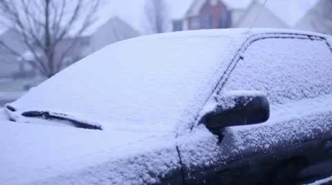 Man brushing snow off of car while in snows Stock Footage 18007170