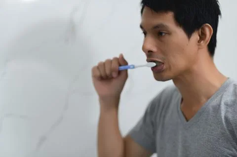 Man Brushing Teeth in Bathroom with Focus on Daily Hygiene Routine Stock Photos