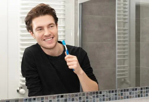 Man brushing teeth in bathroom 스톡 사진