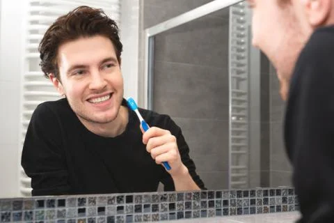 Man brushing teeth in bathroom 스톡 사진
