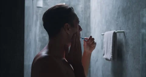 Man brushing teeth bathroom suddenly feels toothache grabs cheek in pain side Stock Footage 264743532