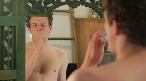Man brushing teeth in front of mirror Stock Footage 40842798