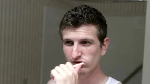 Man brushing teeth in mirror Stock Footage 11985222