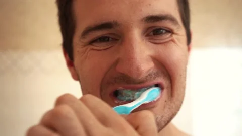 Man brushing teeth while standing in front of the camera Stock Footage 158283503