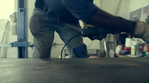 Man brushing a work surface clean in a workshop Stock Footage 279004314