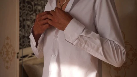 A man buckles buttons on his shirt Stock Footage 127431353