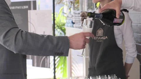 A man at a buffet table poured champagne into a glass Stock Footage 143021928