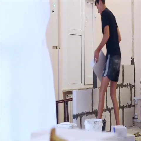 Man build a new wall of foam concrete bricks in the office Stock Footage 69460209