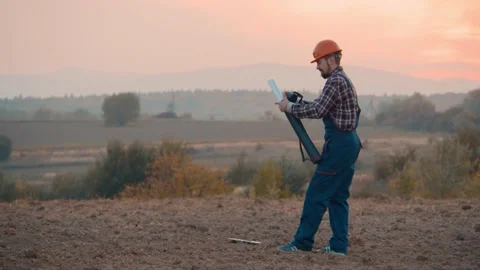 Man builder architect closes the paper with the construction plan and puts it in Video stock 169775258