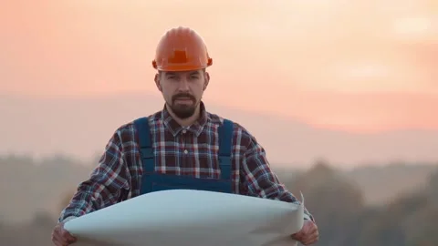 Man builder architect reading draft in field. Engineer unrolling and examining Stock Footage 169774149