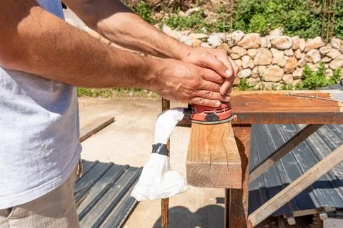 Man Builder Carpenter Sanding Surface Wooden Board Beam With Orbital Sander.. Photos