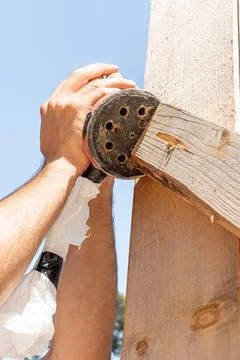 Man Builder Carpenter Sanding Surface Wooden Board Beam With Orbital Sander.. Photos