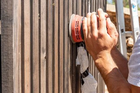 Man Builder Carpenter Sanding Surface Wooden Board Beam With Orbital Sander.. 스톡 사진