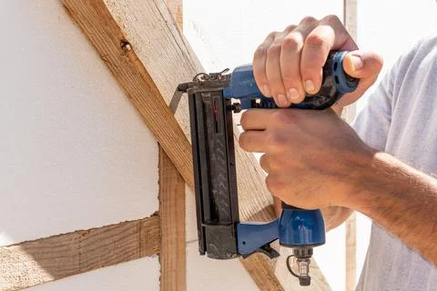 Man Builder craftsman Carpenter hammers nails on Wooden Board Beam With finis 写真素材