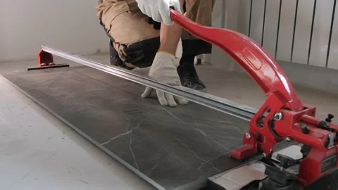 Man builder cuts ceramic panel with tile cutter machine Video stock 152850109