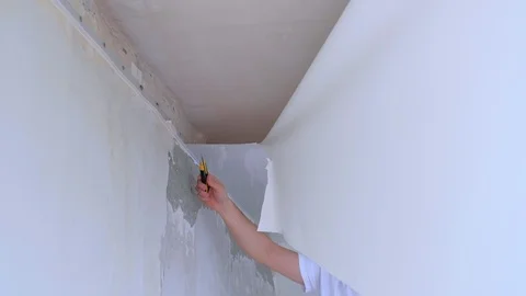 Man builder dismantling of stretch suspended ceiling cuts it using knife. Stock Footage 123346319