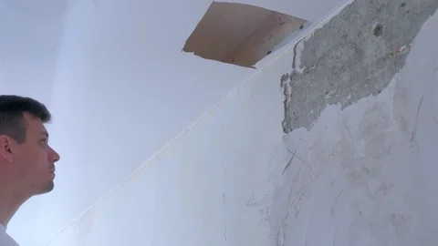 Man builder dismantling of stretch suspended ceiling cutting it using knife. Vídeo Stock 123779357