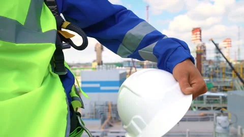 Man builder engineer hand safety uniform holding protective helmet at refinery Vídeos de archivo 252715588
