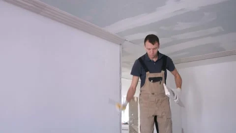 Man builder grinds plaster fretwork with knife in apartment Video stock 151784395