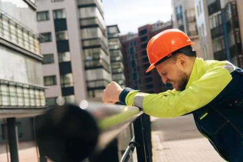 Man builder in helmet closeup, upset in shock, holding his head. Fire fightin Stock Photos