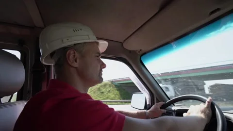 Man builder in helmet drives car minivan and looks away Stock Footage 167516101