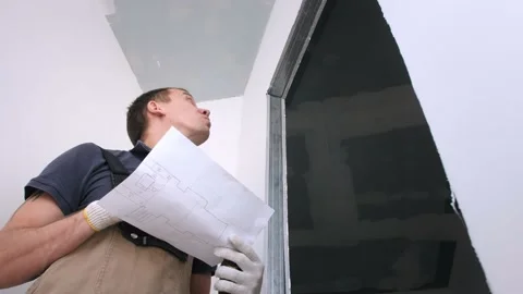 Man builder in jumpsuit draws scheme on white paper closeup Video stock 151987616