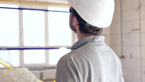 A man builder looks at a construction drawing in a building. Stock Footage 160887549