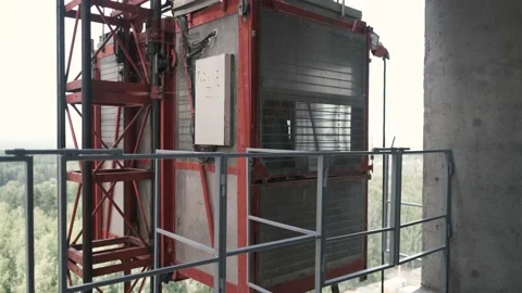 A man builder opens the doors of a freight construction elevator Video stock 138007086